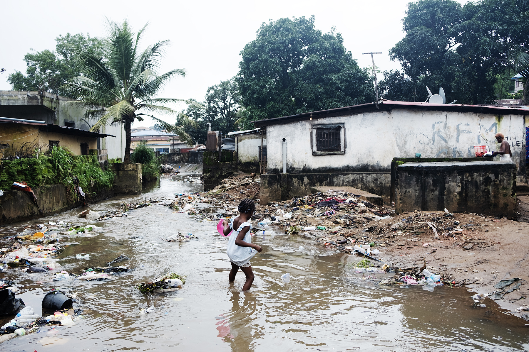 Pige der går i oversvømmet område i Sierra Leone